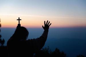 silhouette di donna in ginocchio giù preghiere per culto Dio a cielo sfondo. cristiani pregare per Gesù Cristo per calma. nel mattina persone avuto per un' silenzioso posto e pregato. copia spazio. foto