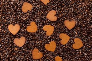 biscotti di panpepato a forma di cuore sullo sfondo di chicchi di caffè foto