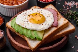 delizioso nutriente inglese prima colazione con fritte uova, pomodori e avocado foto