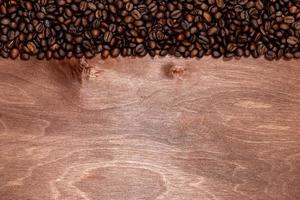 strisce di chicchi di caffè su sfondo texture in legno scuro, copia spazio per il testo