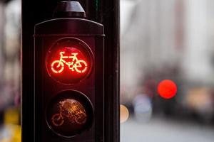 Segnale stradale di bicicletta rossa con sfondo sfocato della città foto