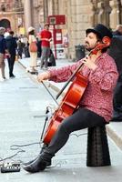 bologna, Italia, aprile 16, 2022, strada esecutore, giocando violoncello nel il storico centro quartiere di bolognese. musicista di strada su strada concetto. foto