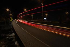 bellissimo Visualizza di mezzi di trasporto luci su il strada a notte tempo foto