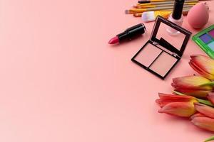 luminosa estate ombretto tavolozza e trucco prodotti nel rosa cosmetico Borsa su rosa sfondo foto