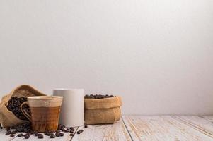 tazze da caffè e sacchetti di chicchi di caffè su un tavolo di legno