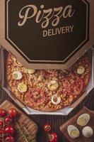 pizza brasiliana con mozzarella, mais, pancetta, uova, pomodoro e origano in una scatola di consegna