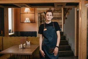 una giovane cameriera sorridente è in posa in un ristorante foto