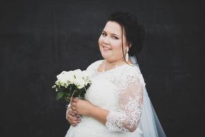 ritratto di un' pieno sposa con un' mazzo su un' buio sfondo. foto