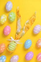 colorato dipinto Pasqua uovo decorato con un' tovagliolo nel il forma di un' coniglietto su un' giallo sfondo foto