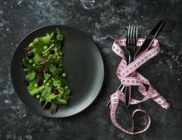 insalata di dieta di foglie di lattuga, spinaci e piselli su uno sfondo scuro foto