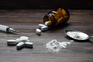 farmaci impostato - polvere e pillole e siringa su di legno sfondo foto