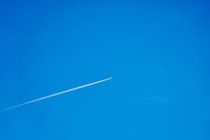 una scia di un aereo nel cielo azzurro e limpido foto