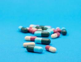 verde capsula pillola su blu sfondo tavolo medicina vitamina antibiotico e medico trattamento di ospedale e clinica foto