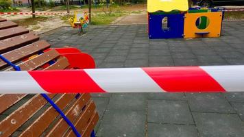 bambini è terreno di gioco chiuso e avvolto nel allarme attenzione nastro per globale coronavirus quarantena.no bambini su campi da gioco. foto