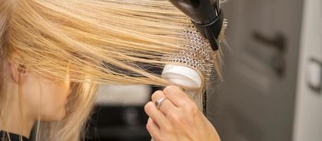 mano essiccazione capelli di donna foto