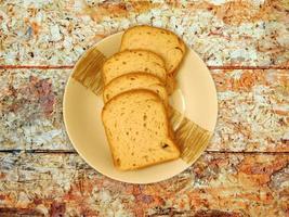 pane a fette su un piatto di ceramica su uno sfondo di tavolo in legno foto