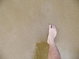 piede maschile nella sabbia foto