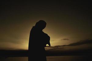 silhouette giovane asiatico musulmano uomo preghiere su tramonto, ramadan Festival concetto foto