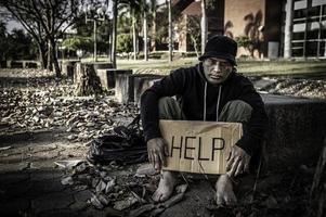 asiatico uomo è senza casa a il lato strada, a sconosciuto ha per vivere su il strada solo perché lui ha no famiglia. foto