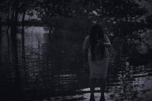 ritratto di asiatico donna rendere su fantasma viso a il palude, orrore nel acqua scena, spaventoso a fiume, halloween manifesto, thailandia persone foto