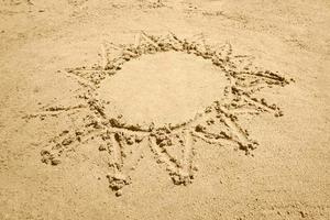 sole disegno su sabbia foto