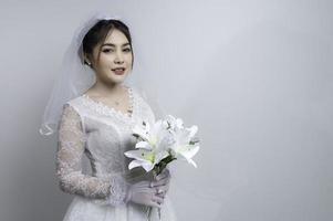 ritratto di asiatico donna indossare sposa con fiore su bianca sfondo, matrimonio concetto foto