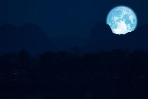 luna rosa sul cielo notturno torna sopra la montagna della siluetta foto