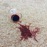 bicchiere di rosso vino abbattere su tappeto, vino rovesciato su tappeto foto