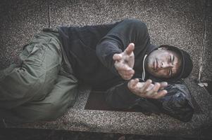 asiatico uomo è senza casa a il lato strada, a sconosciuto ha per vivere su il strada solo perché lui ha no famiglia. foto