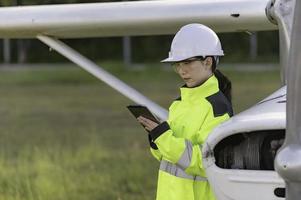 tecnico che ripara il motore dell'aereo, ingegneria aerospaziale femminile che controlla i motori degli aerei, manutenzione meccanica asiatica ispeziona il motore dell'aereo foto