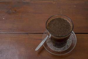 vicino su foto un' tazza di arabica caffè con cucchiaio a partire dal alto angolo. il foto è adatto per uso per caffè negozio sfondo, menù manifesto e caffè soddisfare media.