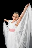 ragazza ballerina nel bianca lungo vestito danza su nero sfondo foto
