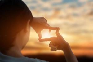 futuro pianificazione concetto. vicino su di giovane donna mani fabbricazione un' telaio cartello al di sopra di tramonto cielo. nuovo anno pianificazione e visione concetto. foto