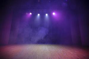 un' palcoscenico per spettacoli con viola tende, legna pavimento e tutti nel Fumo. teatrale sfondo. foto
