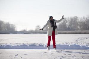 un' donna va ghiaccio pattinando nel inverno su un ghiacciato lago. foto