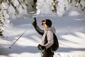 giovane donna godendo inverno giorno di sciare divertimento nel il neve foto