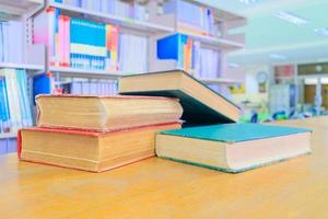 vecchio libro rosso - verde. e mucchio trattato nel scuola biblioteca su di legno tavolo. sfocato libreria sfondo. formazione scolastica apprendimento concetto con copia spazio Inserisci testo foto