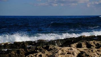 blu mare onda e bianca schiuma e spruzzata. pietra spiaggia su isola di Malta, no sabbioso spiaggia. estate vacanza confine telaio concetto. tropicale isola vacanza sfondo. turista viaggio bandiera design modello. foto