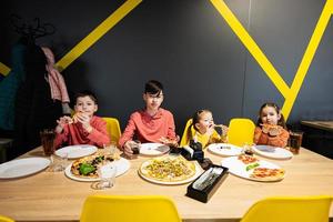 quattro bambini mangiare italiano Pizza nel pizzeria. bambini mangiare a bar. foto