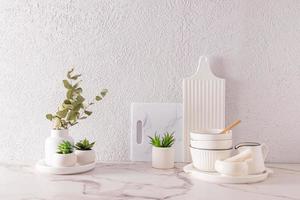 bellissimo bianca nel minimalista stile cucina sfondo con bianca utensili e interno fiori nel ceramica pentole. elegante davanti Guarda. un' copia spazio. foto