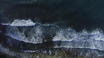 un maestoso Visualizza di onde Crashing lungo il spiaggia, catturato a partire dal un aereo prospettiva. foto