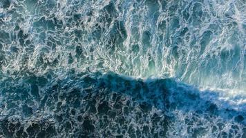 un maestoso Visualizza di onde Crashing lungo il spiaggia, catturato a partire dal un aereo prospettiva. foto