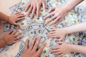 bambini mani su dollaro i soldi. distribuzione di famiglia proprietà. foto
