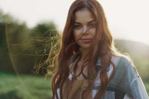 ritratto di un' donna con un' bellissimo Sorridi e dritto denti su un' estate giorno nel il tramonto con volante Riccio capelli foto