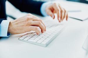 un' uomo con un' tastiera su un' del desktop ufficio Lavorando a un' computer foto