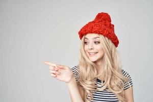 bionda nel un' a strisce maglietta rosso cappello in posa studio foto