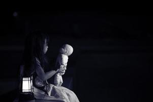 triste bambino fantasma a notte, halloween Festival concetto, venerdì 13, orrore film scena, A ragazza con Bambola foto