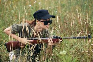 militare donna riparo con Armi nel mano a caccia fresco aria nero berretto foto