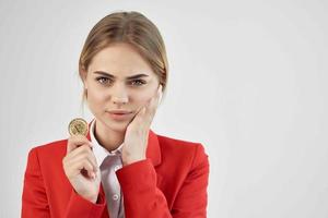 donna d'affari nel un' rosso giacca oro moneta bitcoin leggero sfondo foto