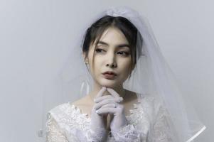 ritratto di asiatico donna indossare sposa con fiore su bianca sfondo, matrimonio concetto foto